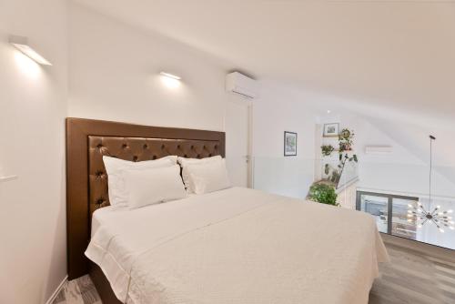 a white bedroom with a large bed with white sheets at VILLA STONE PEARL SUTIVAN - exceptional luxury new three-room villa - private pool and jacuzzi - perfect location right next to the town center and the beach - secured parking space in Sutivan