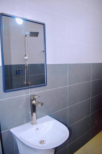 a bathroom with a sink and a mirror at JG Luxury Hotel in Dodoma