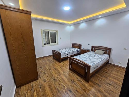 two beds in a room with wooden floors at فيلا في كينج مريوط in Alexandria