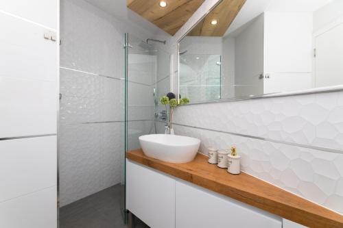 a white bathroom with a sink and a mirror at VILLA STONE PEARL SUTIVAN - exceptional luxury new three-room villa - private pool and jacuzzi - perfect location right next to the town center and the beach - secured parking space in Sutivan