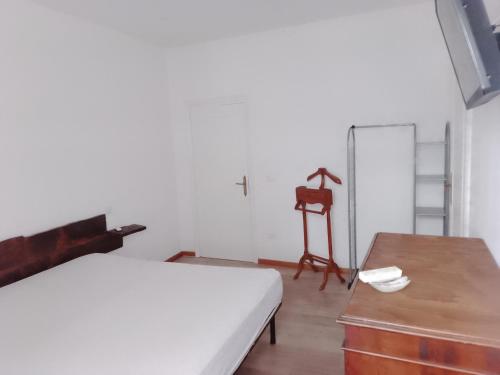a bedroom with a bed and a desk and a chair at B&B Yle in Cetraro