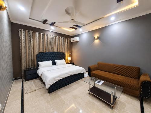 a bedroom with a bed and a couch at Opal Orchid House in Islamabad