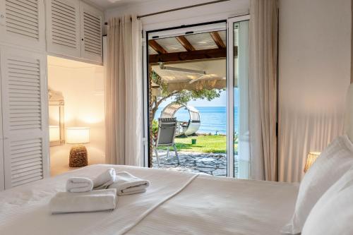 a bedroom with a bed with a view of the ocean at Corfu Glyfada Beach Apartment 13 in Glyfada