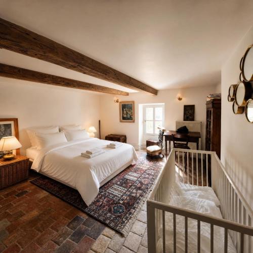 a bedroom with a white bed and a staircase at Le Jeu de Paume - Bail Partner in Mailly-le-Château