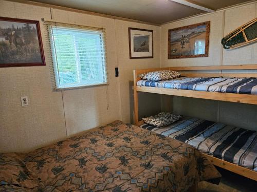 a bedroom with two bunk beds and a window at Hidden Creek Cabin in Beaverlodge