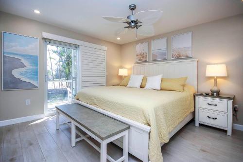 a bedroom with a bed with a ceiling fan and a window at Sanibel Arms West Unit A1 in Sanibel