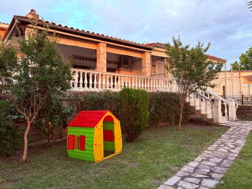 a colorful play house in the yard of a house at Villa Emara Mangana in Mángana