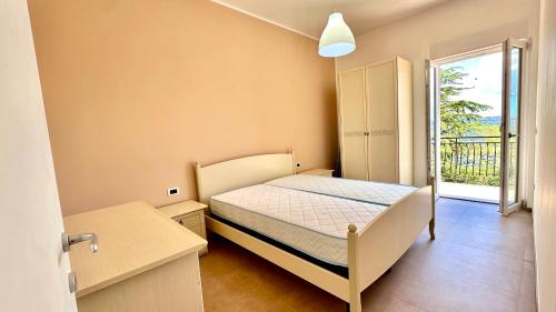 a small bedroom with a bed and a balcony at Cilento HOME in Ogliastro Cilento
