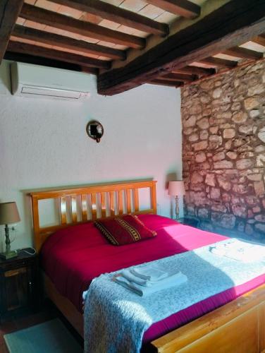 a bedroom with a large bed in a stone wall at Tudesia Charming house in Todi