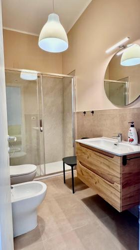a bathroom with a sink and a toilet and a mirror at Cilento HOME in Ogliastro Cilento