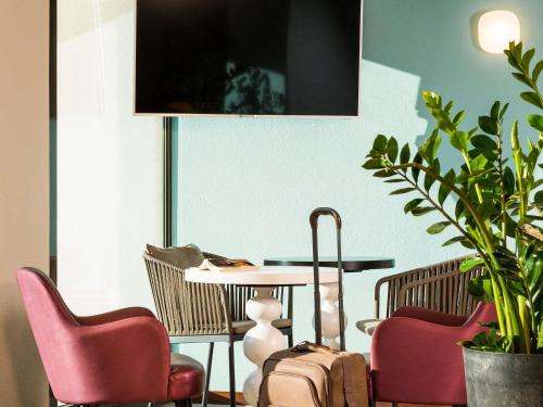 a dining room with chairs and a table and a table at Aparthotel Adagio Access Rennes Centre in Rennes