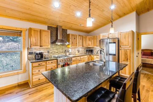 a kitchen with wooden cabinets and a black counter top at Little Bear in Maggie Valley