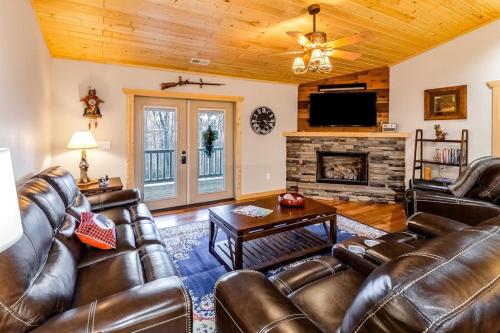 a living room with leather furniture and a fireplace at Little Bear in Maggie Valley