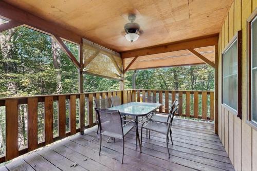 a screened porch with a table and chairs on it at Hollow's End in Whittier