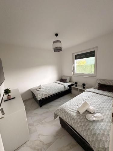 a bedroom with two beds and a window at Holiday Home Norr in Bihać