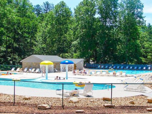 a swimming pool with a playground with chairs and umbrellas at Narnia on Earth in Lake Lure
