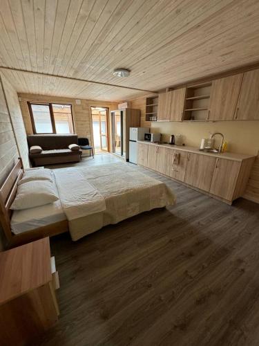 a large bedroom with a large bed and a kitchen at GreenHotel in Chornomorsk