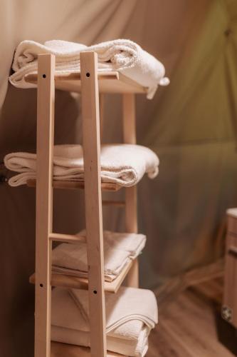 a wooden towel rack with towels on it at Manteiros Glamping in Canas de Senhorim