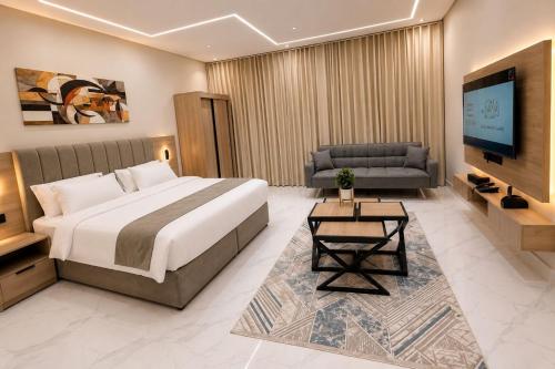 a hotel room with a bed and a couch and a television at إليت إن - ELITE INN Serviced Apartments in Qal'at Bishah