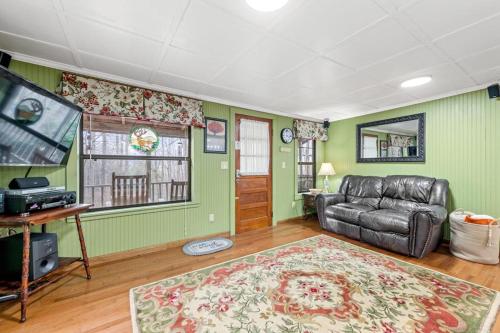 a living room with green walls and a leather couch at Hidden Creek Cabin in Franklin