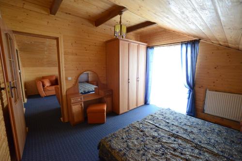 een slaapkamer met een bed, een spiegel en een raam bij Cottage Kurshevel in Slavske
