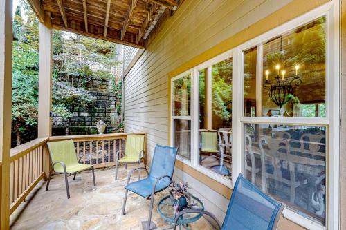 a porch with chairs and a table and windows at Link Vacation in Whittier
