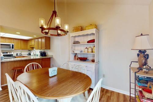 a kitchen with a wooden table and white chairs at Rumbling Bald Resort Unit 2004 in Lake Lure