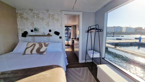 a bedroom with a bed and a large window at Alma Flotante Muxía in Muxia