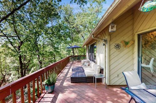 a deck with a couch and chairs on a house at Yopp's Treehouse in Lake Lure