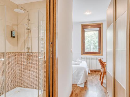 a bathroom with a shower and a sink and a table at Aida's Hostal in Puentes de García Rodríguez