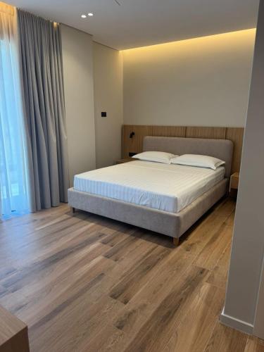 a bedroom with a bed and a wooden floor at EFFÉI Boutique Hotel in Sarandë