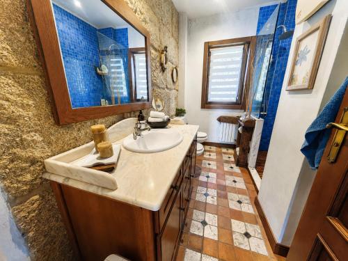 a bathroom with a sink and a mirror at Vila Xocas in Baiona