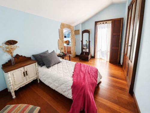 a bedroom with a bed and a wooden floor at Vila Xocas in Baiona