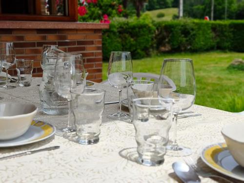 a table with glasses and plates on a table at La Casuca de Marisa in Solórzano