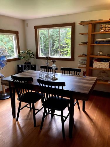 a dining room with a wooden table and chairs at Cabin by the Creek in Roberts Creek