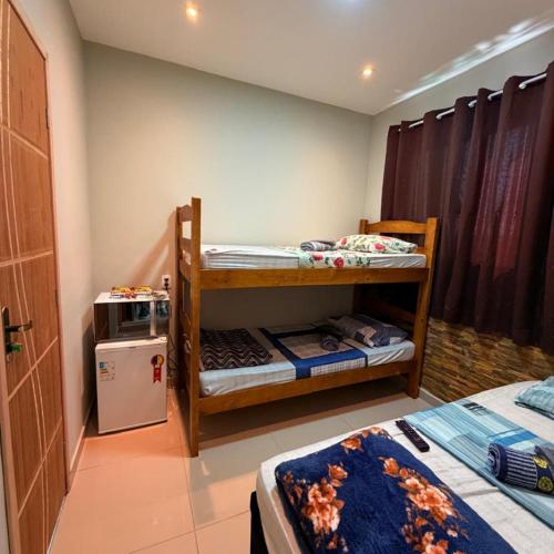 a room with two bunk beds and a refrigerator at Guaru Inn Hostel in Guarulhos