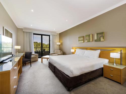 a hotel room with a bed and a television at Mercure Kooindah Waters Central Coast in Wyong