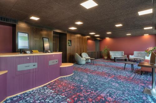 a lobby with a waiting room with chairs and tables at b-smart hotel Widnau in Widnau