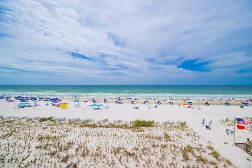 a group of people on a beach with the ocean at Sea Glass 305 in Gulf Shores