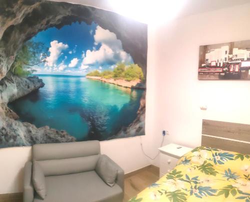 a bedroom with a painting of a river on the wall at Apartamento La Cueva silencioso in Algarrobo