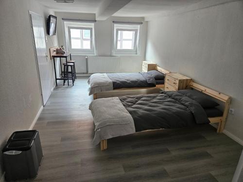 a room with three beds and a table in it at Asanov Retreat in Northeim
