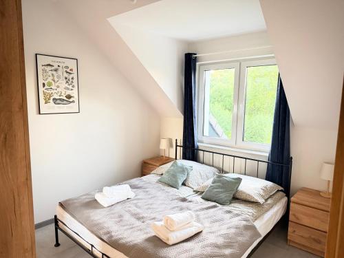 a bedroom with a bed with two towels on it at Lisia Górka in Debina