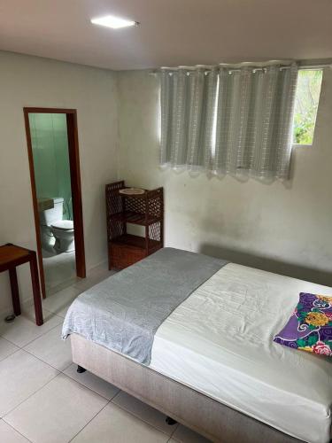 a bedroom with a bed and a bathroom with a toilet at Hostel e Suites Caminho do Vale in Palmeiras