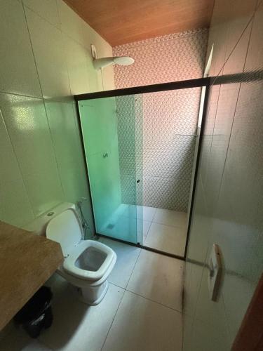 a bathroom with a toilet and a shower at Hostel e Suites Caminho do Vale in Palmeiras