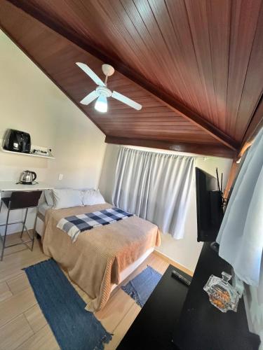 a bedroom with a bed and a ceiling fan at Pousada Moradia da Fabi in Bragança Paulista