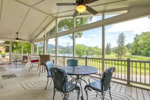 a screened in porch with a table and chairs at Cameron Lakeside in Lake Junaluska