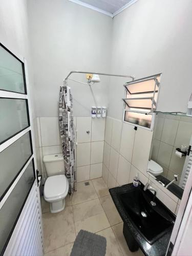 a bathroom with a toilet and a sink at Pousada Moradia da Fabi in Bragança Paulista