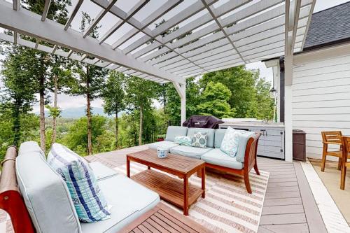 a patio with a white pergola and a table at Mountain Majesty in Mill Spring