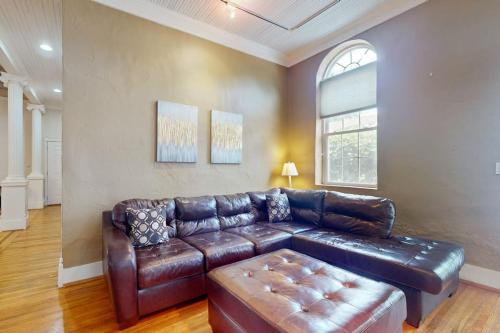 a living room with a leather couch and a window at Mountain Stream Haven in Whittier