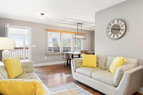 a living room with two couches and a clock on the wall at Upper Lakeshore Living in Lake Junaluska